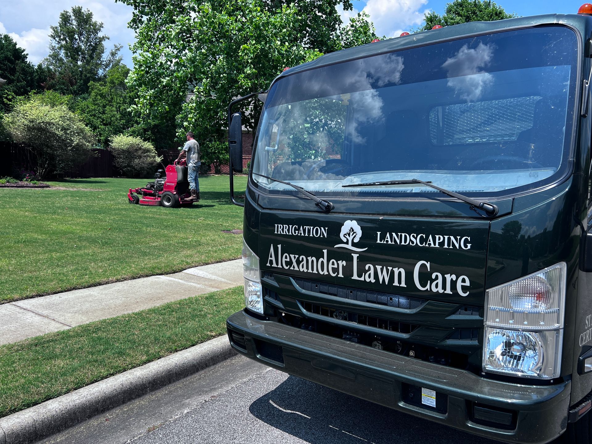 A lawn care truck is parked in front of a lush green lawn.