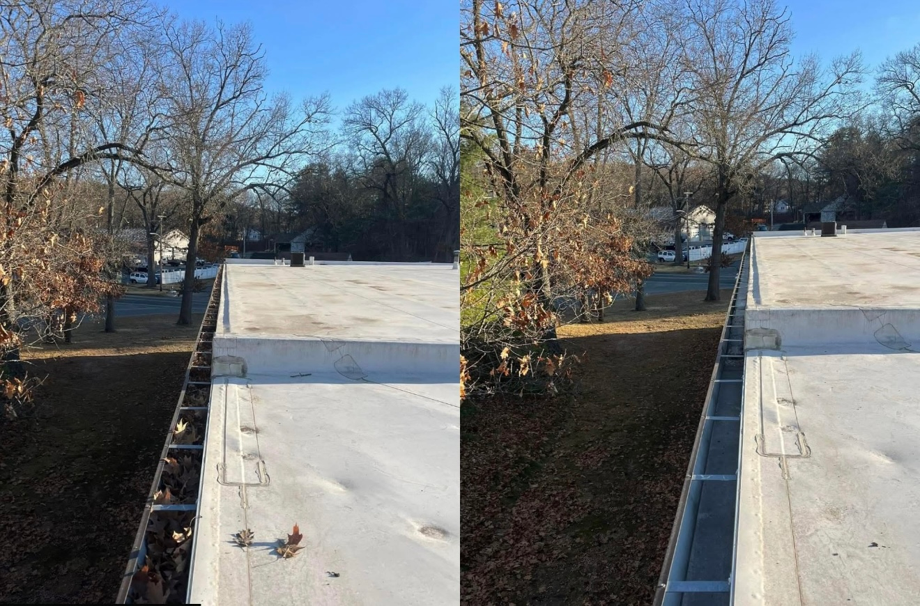 Rooftop with gutters full of leaves; trees in background, clear blue sky.