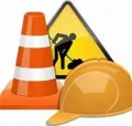 An orange traffic cone, a yellow road work warning sign, and a yellow hard hat grouped together.