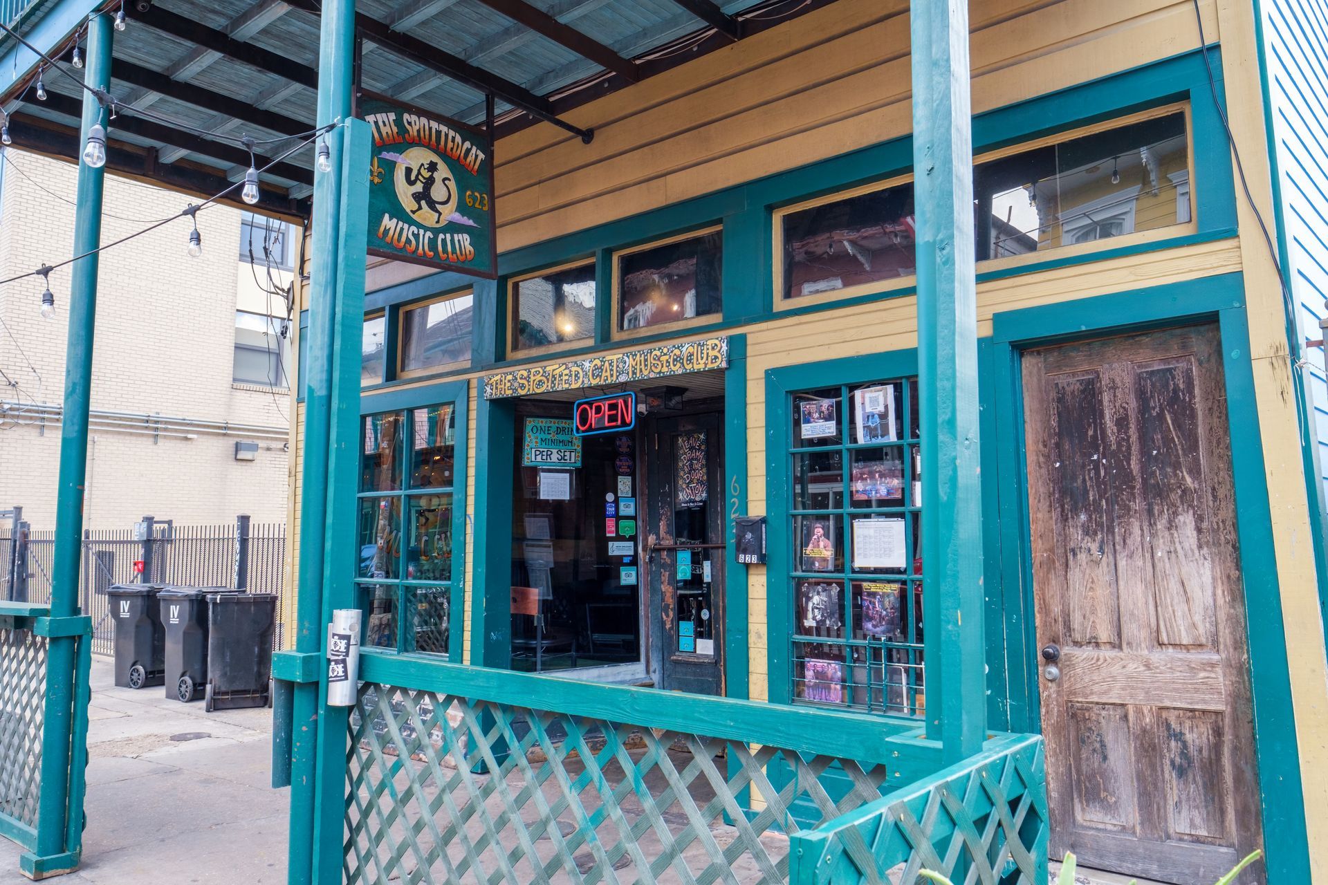 A green and yellow building with a porch and a sign that says ' a ' on it.