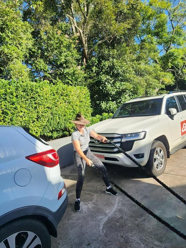 A woman doing rope exercise standing in between parked cars —True Form Fitness In Gwandalan, NSW