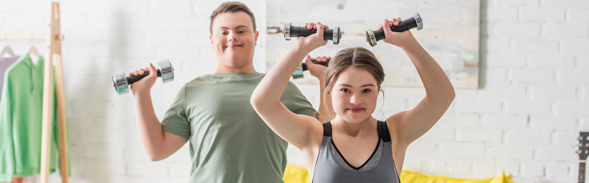 A Man and a Woman Are Holding Dumbbells Over Their Heads —True Form Fitness In Gwandalan, NSW