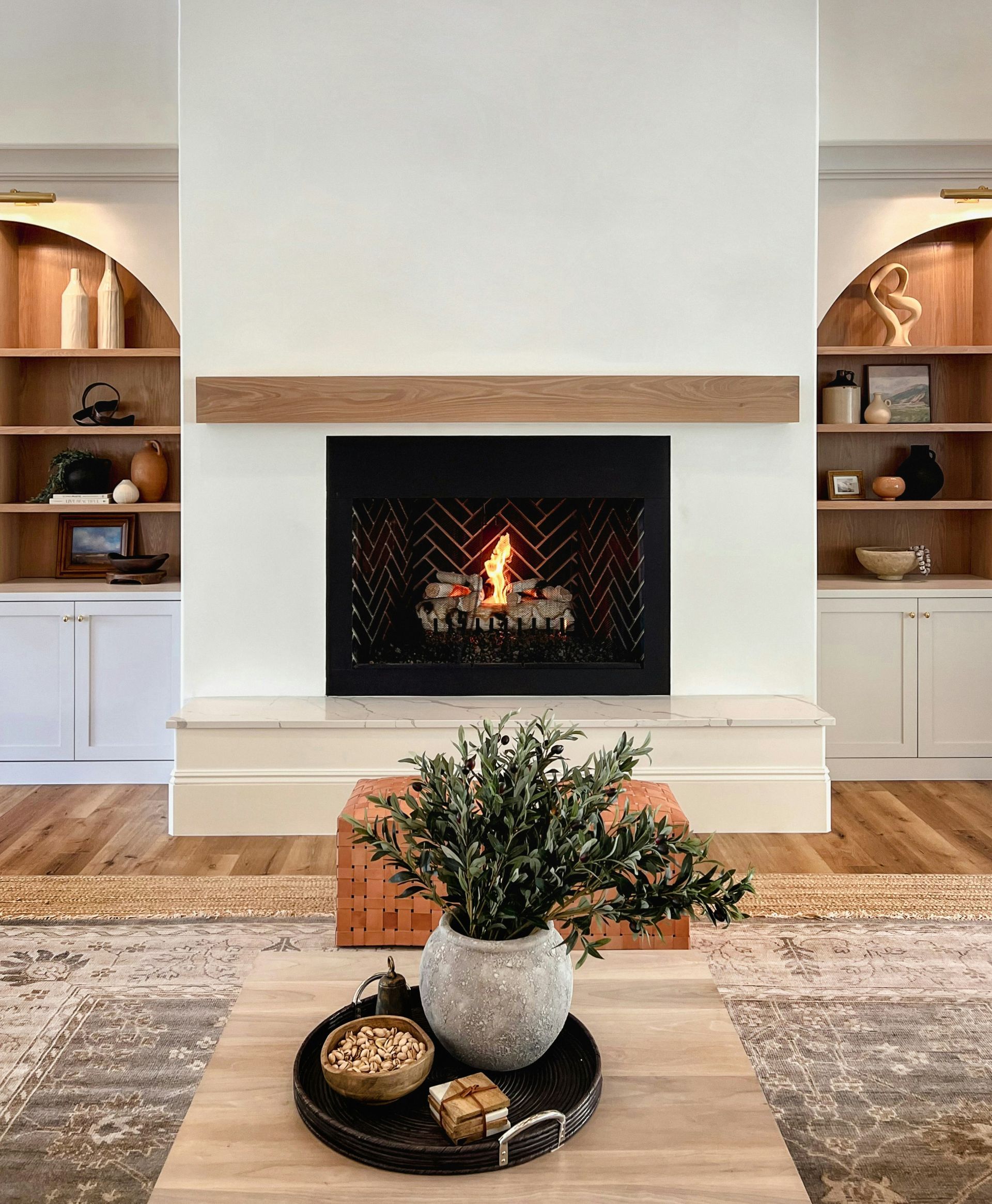 A living room with a fireplace and a coffee table.
