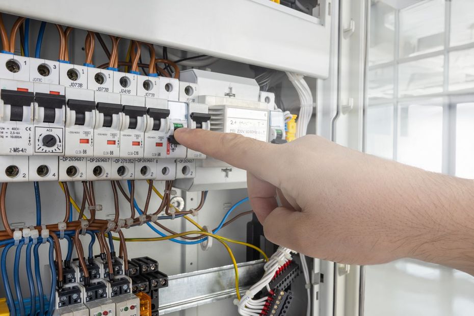 Modern living room with green sofa, fireplace, large wall TV, and wooden chairs near bright windows.