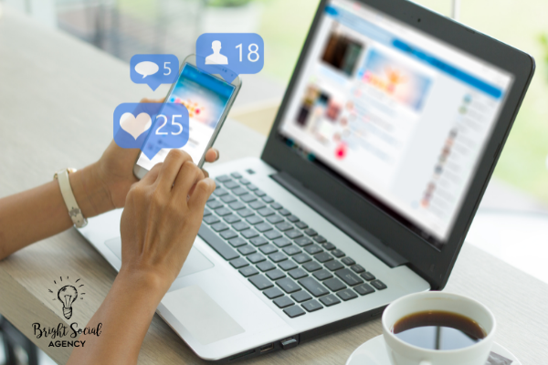 Person using a smartphone with social media icons, laptop, and a cup of coffee.