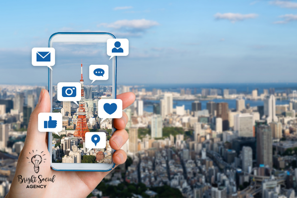 Hand holding a phone with social media icons superimposed over a Tokyo city view.