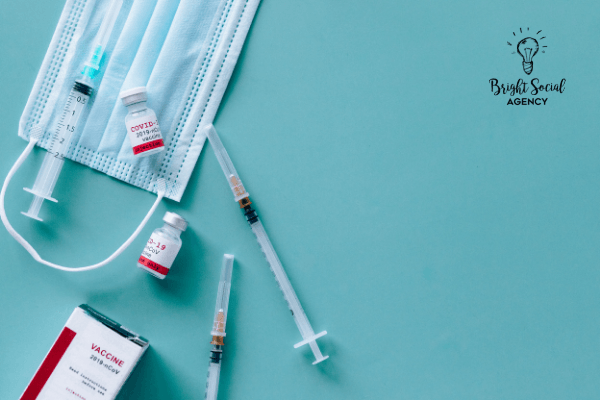 Medical supplies on blue background: face mask, syringes, vials labeled 