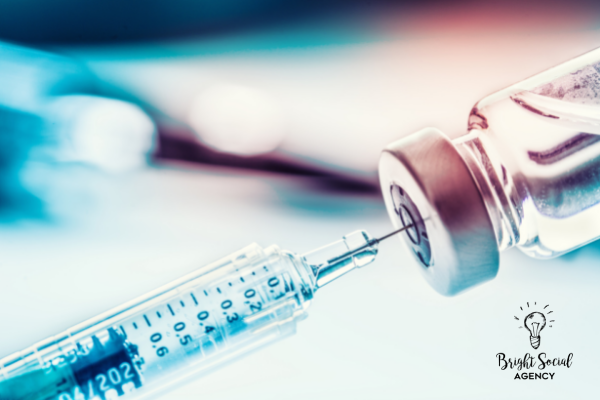 Syringe drawing liquid from vaccine vial. Close-up with blurred background.