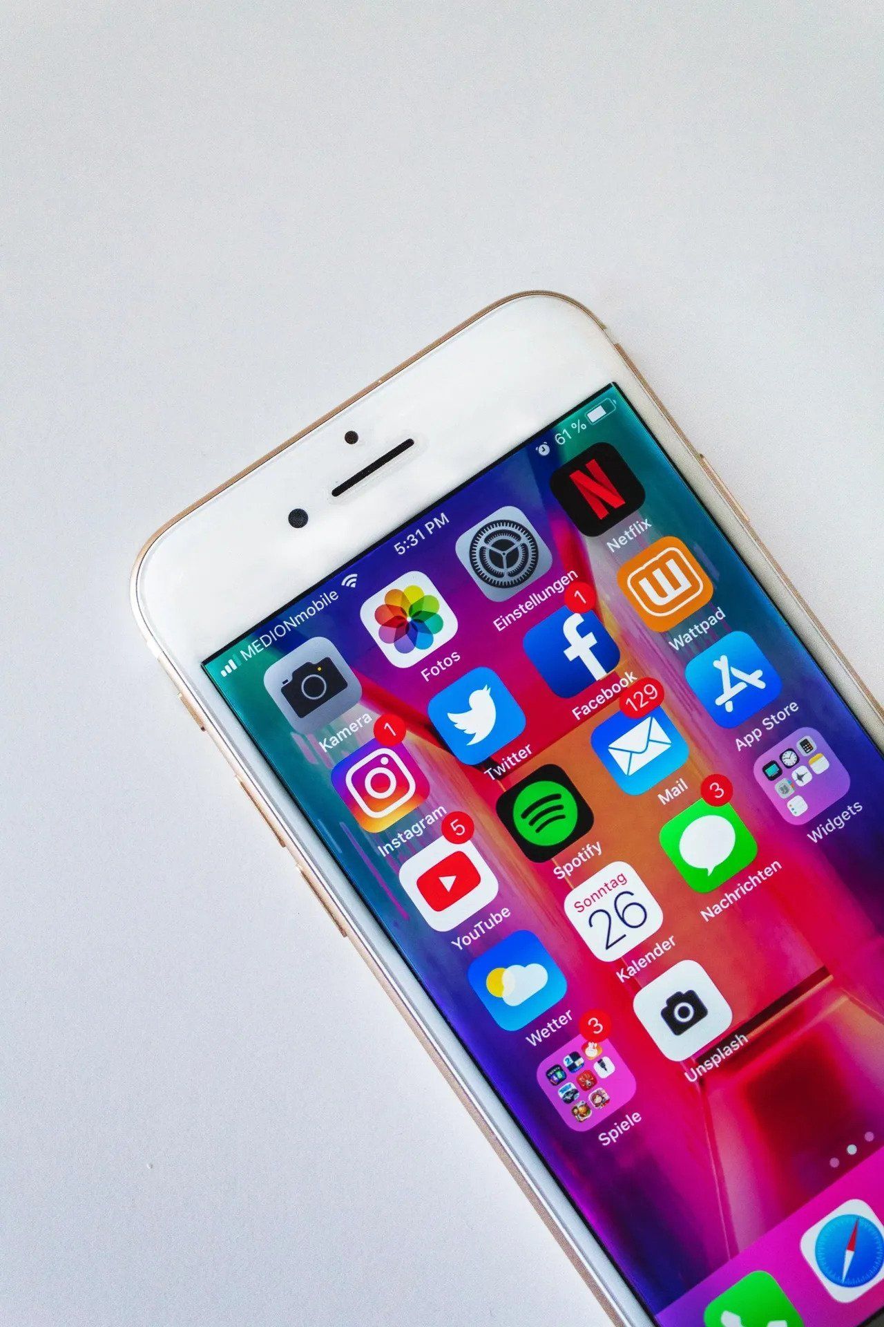 Smartphone with app icons on screen, angled on a white surface.