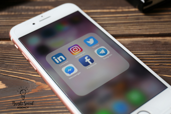 Smartphone displaying social media app icons: LinkedIn, Instagram, Twitter, Facebook, Messenger, and Telegram.