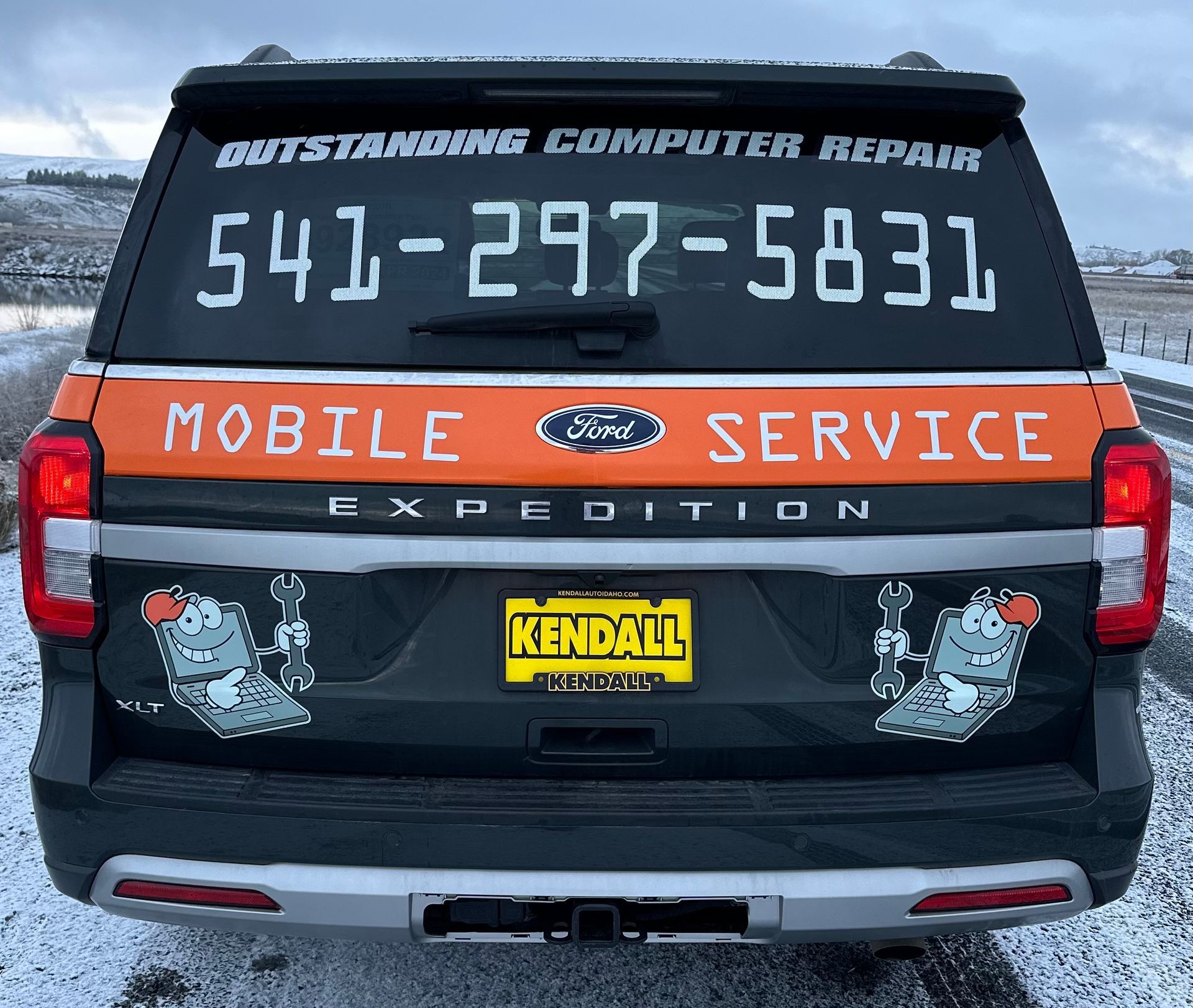 Black expedition SUV with “Mobile Service” signage and phone number on the rear window.
