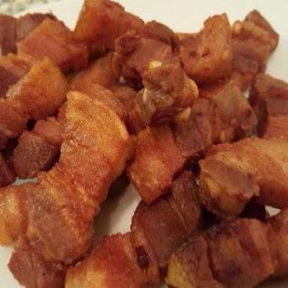 Close-up of crispy fried bacon pieces on a white plate