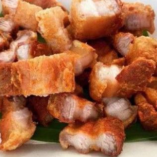 Pile of crispy fried pork belly cubes on a green plate