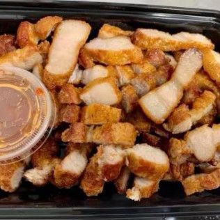 Tray of diced cooked potatoes and bacon with a small cup of dipping sauce