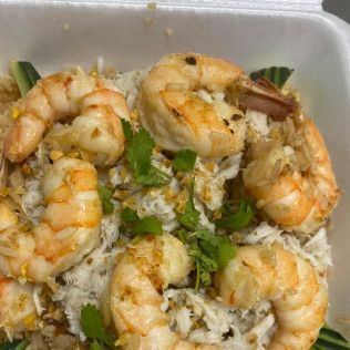 Takeout container with shrimp fried rice topped with green onions