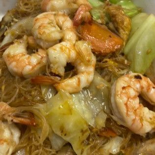Stir-fried noodles with shrimp, cabbage, and vegetables in a close-up view