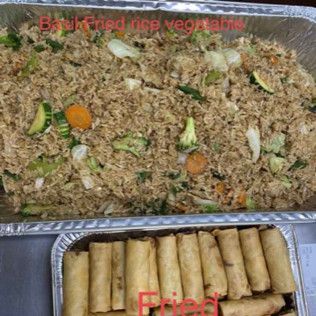 Tray of vegetable fried rice above a tray of fried spring rolls