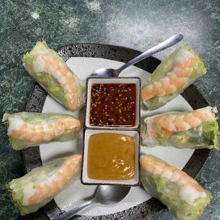 Vietnamese spring rolls arranged around two dipping sauces on a plate