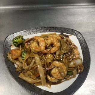 Stir-fried noodles with shrimp and broccoli on a white plate