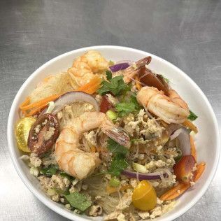 Shrimp salad bowl with mixed greens, herbs, purple onion, and cherry tomatoes