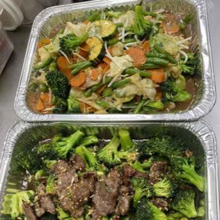 Two foil trays: mixed vegetable stir-fry and beef with broccoli.