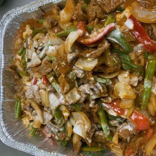 Takeout tray of stir-fried vegetables and chicken with green beans and red peppers