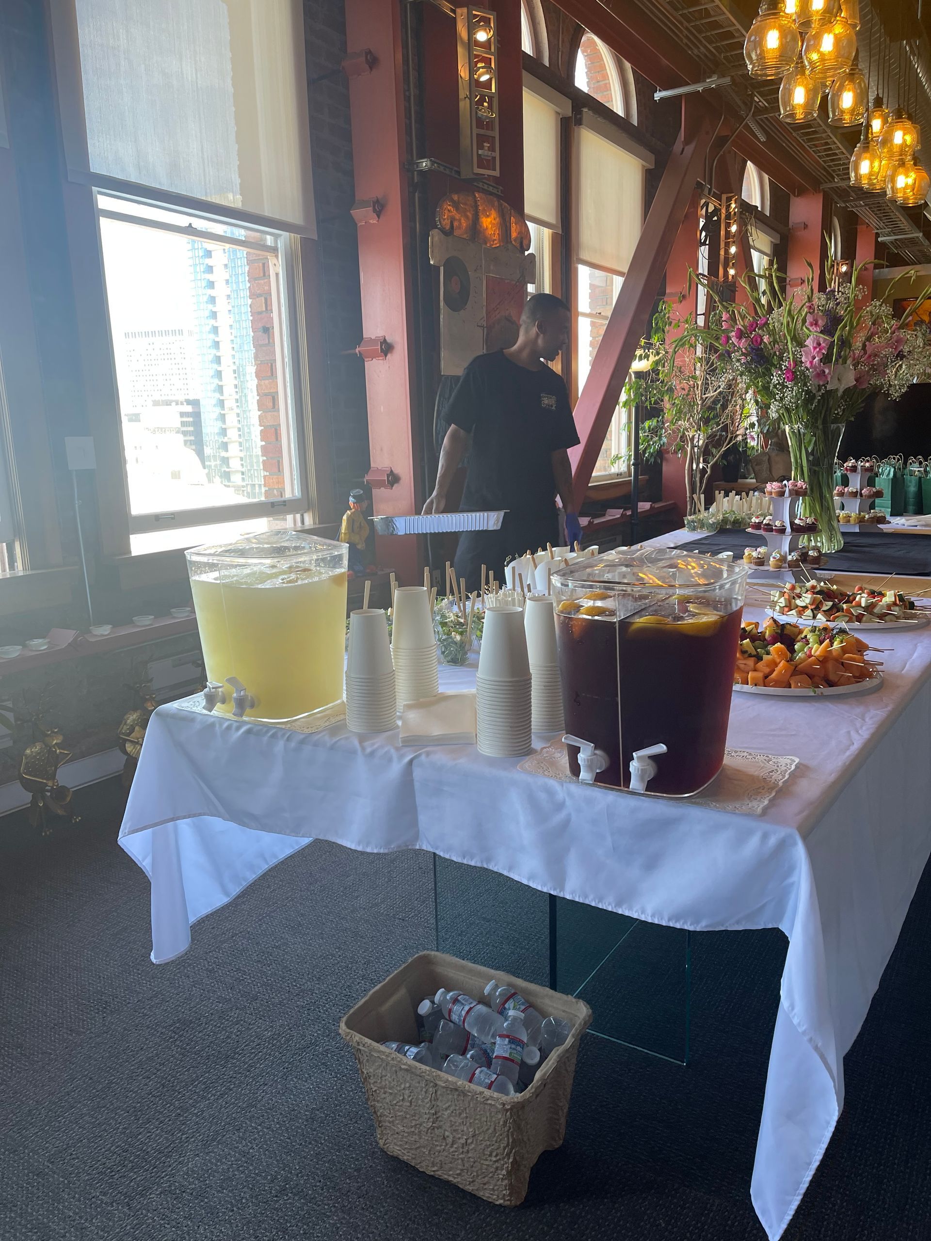 Buffet table with drinks and food in a warmly lit indoor dining room
