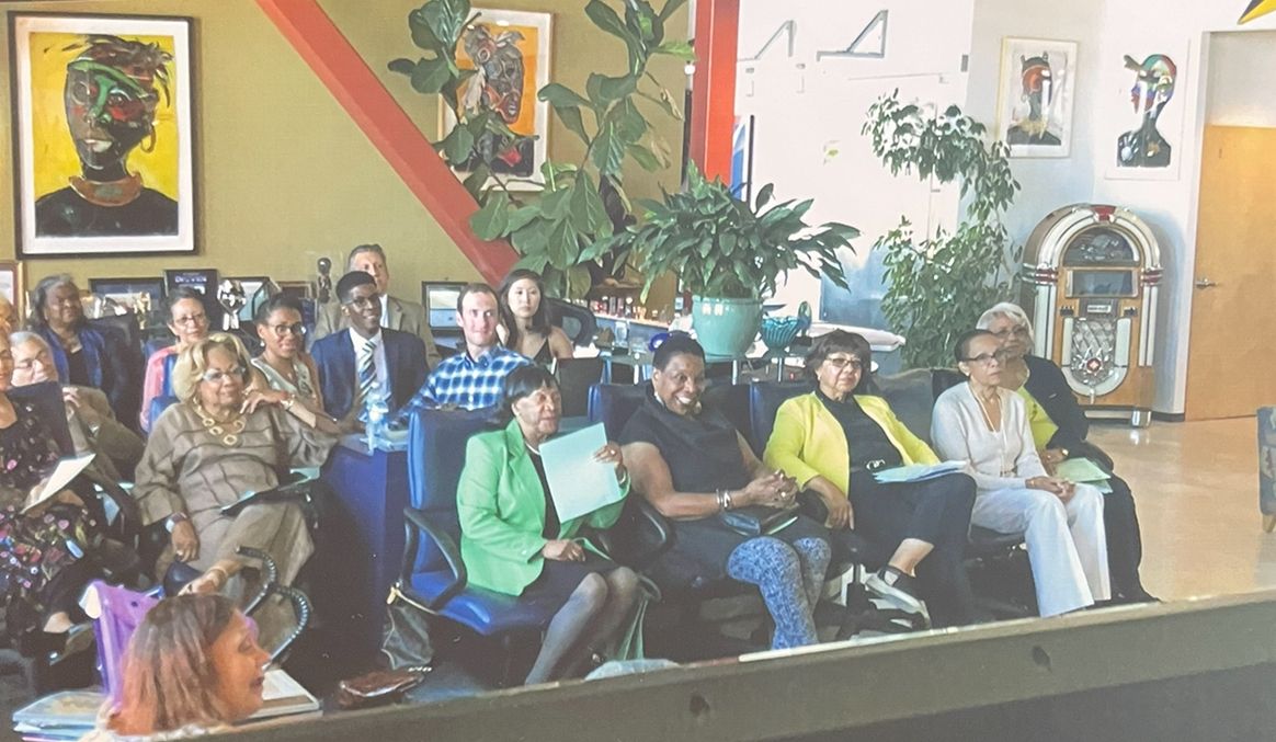 Audience seated in a colorful room, watching a presentation or performance.
