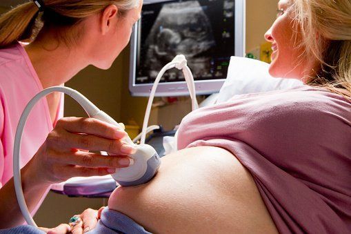 medico effettua una ecografia a donna incinta