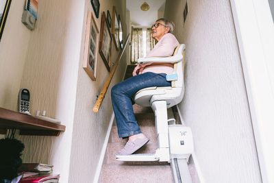Person using a stair lift in a narrow hallway