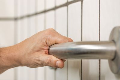 Hand gripping a stainless steel grab bar