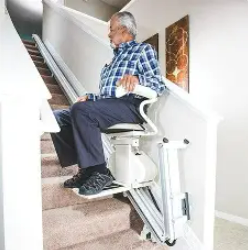 Person using a stair lift in a narrow hallway