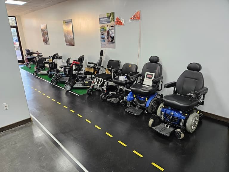 Row of mobility scooters lined up along a wall in a showroom