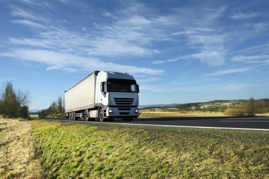 A White Semi Truck is Driving Down a Country Road — JEC Transport in Palmerston, NT
