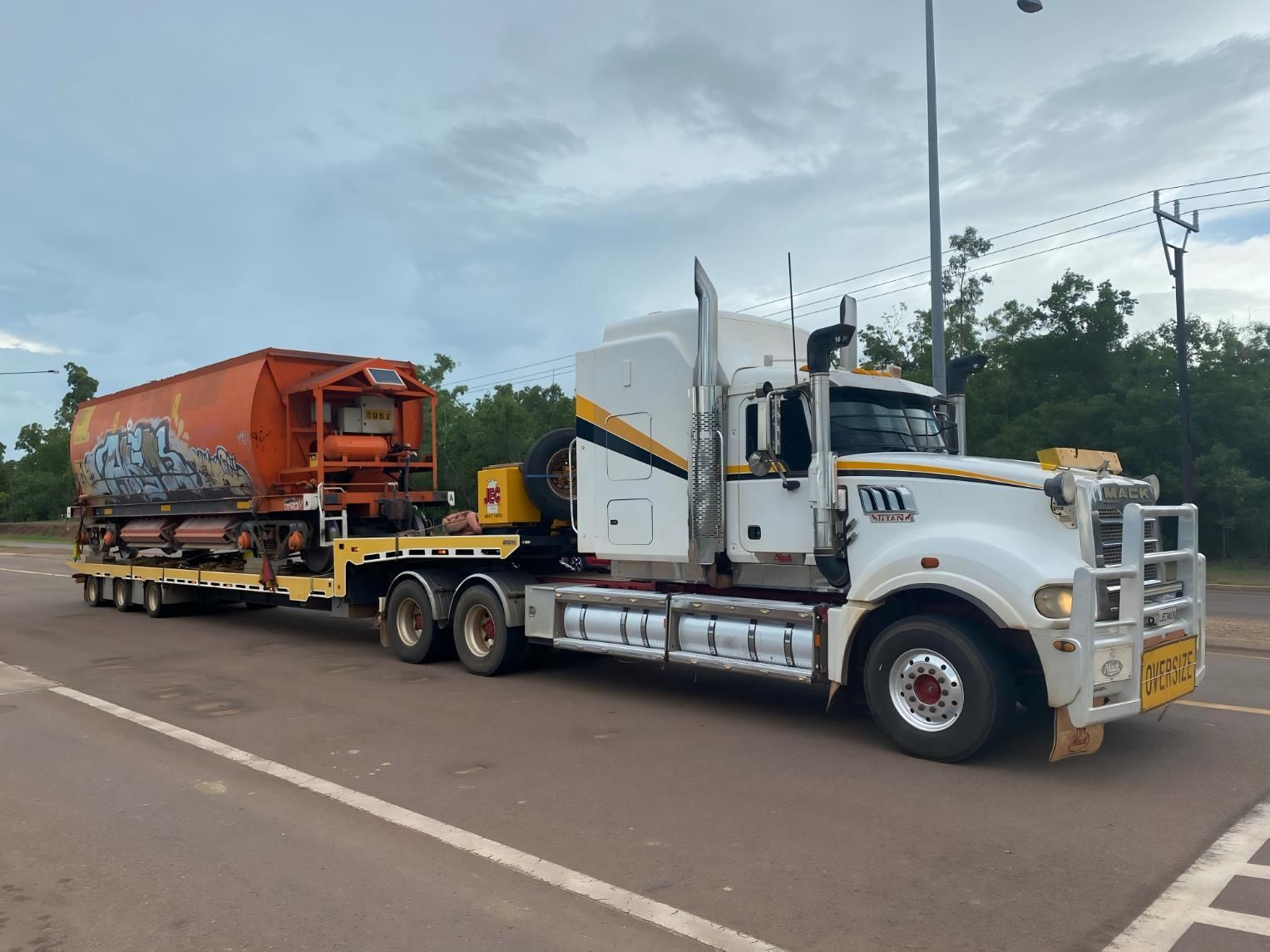 A Semi Truck is Pulling a Trailer With a Train on It — JEC Transport in Winnellie, NT