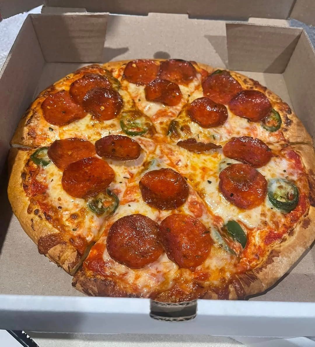 A pepperoni pizza is in a cardboard box