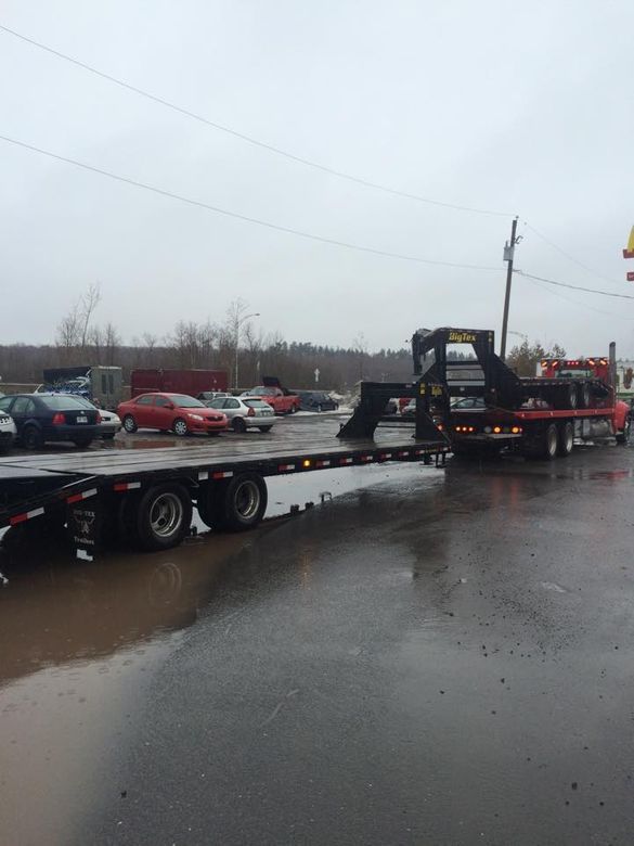 Camion &agrave; plateau stationn&eacute; au bord de l&rsquo;eau sous un ciel nuageux.