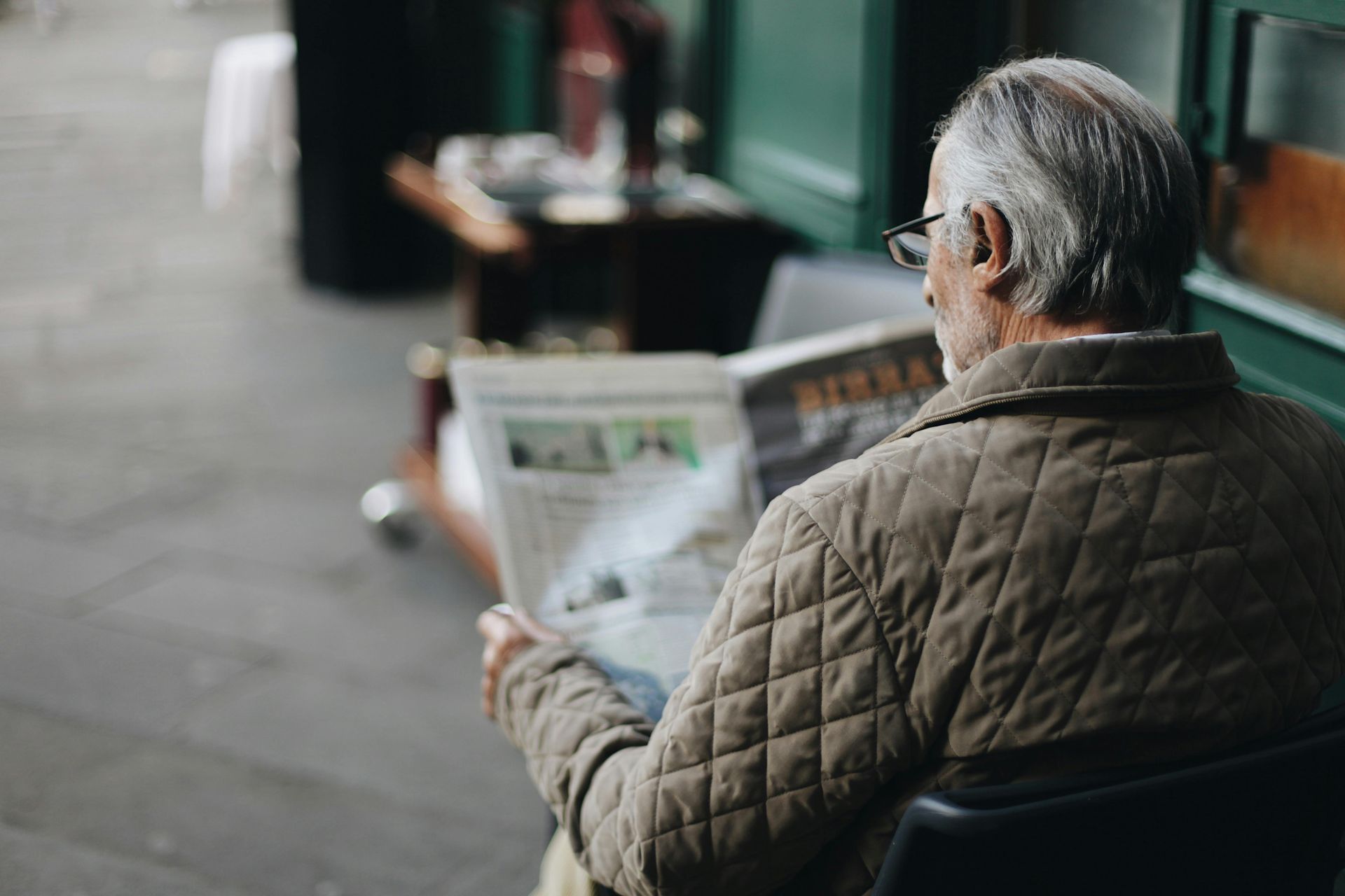 elderly man at home reading the paper