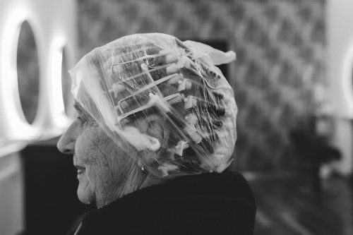 Profile Of A Person Wearing A Plastic Hair Cap, Seated Indoors In A Black Top — Hair Truss & Co In Wallsend, NSW