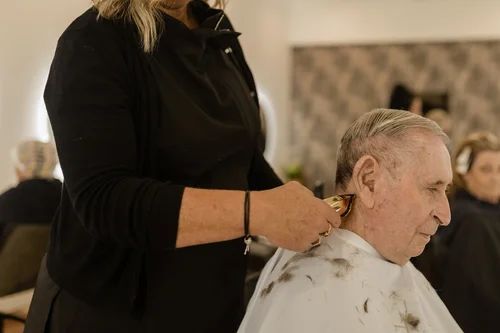 Stylist Cutting an Older MAN’s Hair in a Salon, With a Cape Draped Over His Shoulders — Hair Truss & Co In Wallsend, NSW