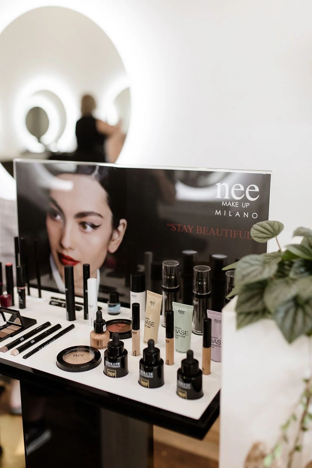 Cosmetics Display on a White Counter Beside a Promotional Poster — Hair Truss & Co In Wallsend, NSW