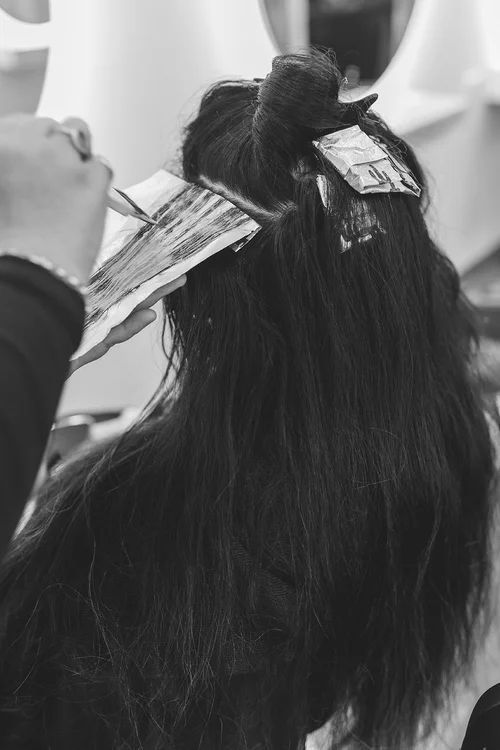 Hairdresser Applying Foil Highlights to Long Dark Hair — Hair Truss & Co In Wallsend, NSW