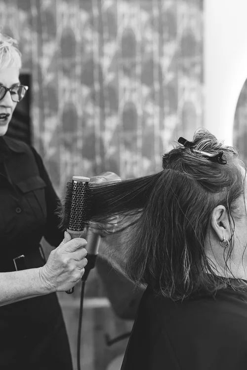 Hairdresser Blow-drying and Brushing a Client's Hair in a Salon — Hair Truss & Co In Wallsend, NSW