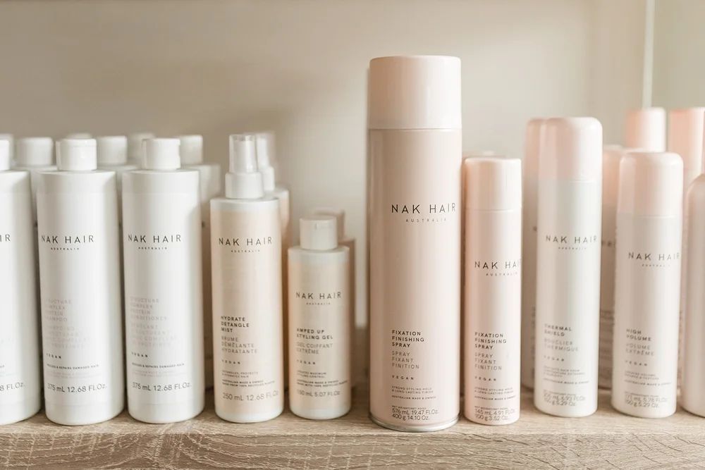 Row of Minimalist White and Blush Haircare Bottles on a Shelf — Hair Truss & Co In Wallsend, NSW