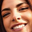 A close up of a woman 's face with a smile on her face.