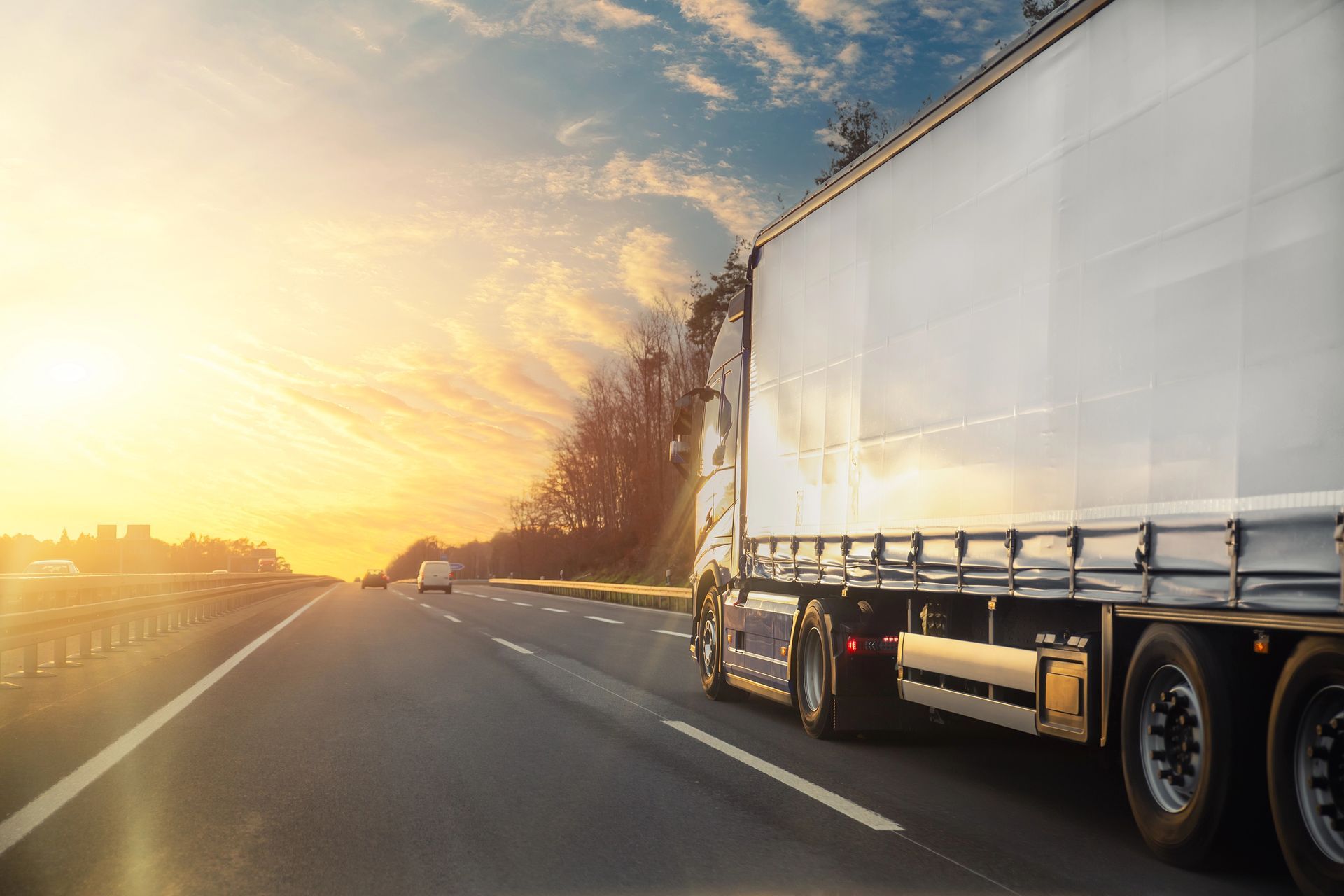 Un camion in autostrada al tramonto.
