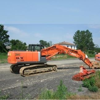 Escavatore Hitachi arancione su una strada sterrata, con braccio teso