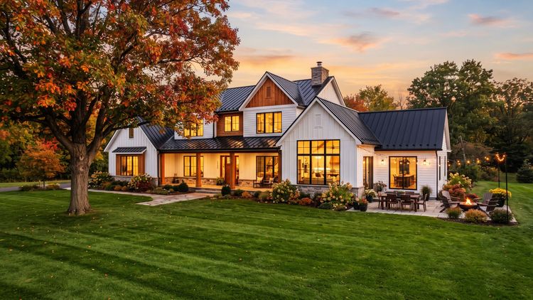 Modern two-story house with warm lights, large windows, and a landscaped lawn at sunset Modern two-story house with warm lights, large windows, and a landscaped lawn at sunset