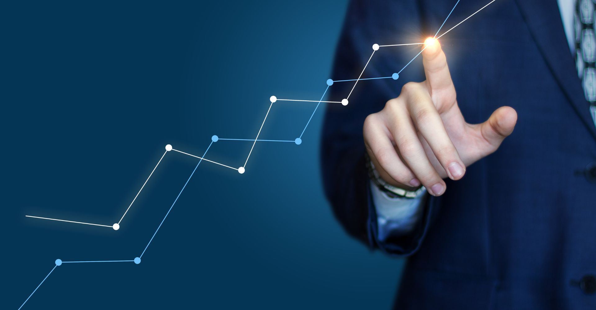 Man in suit reaching out to touch a point on a chart