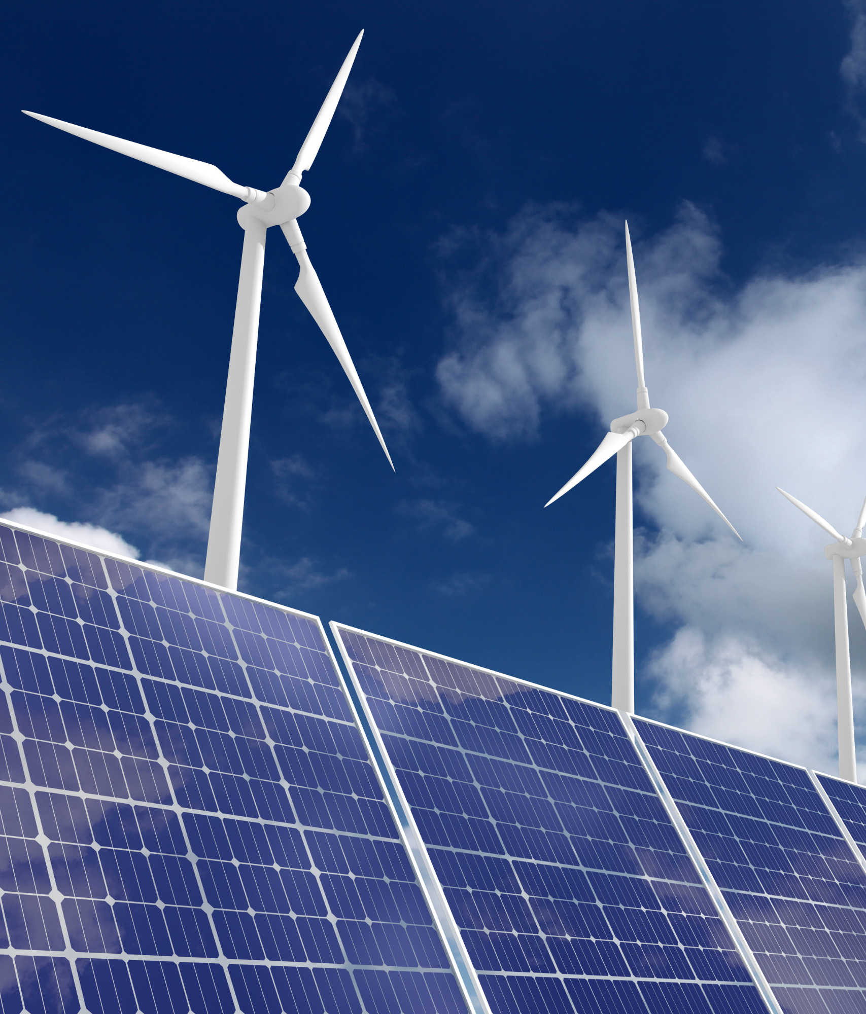 Wind turbines and solar panels against a blue cloudy sky.